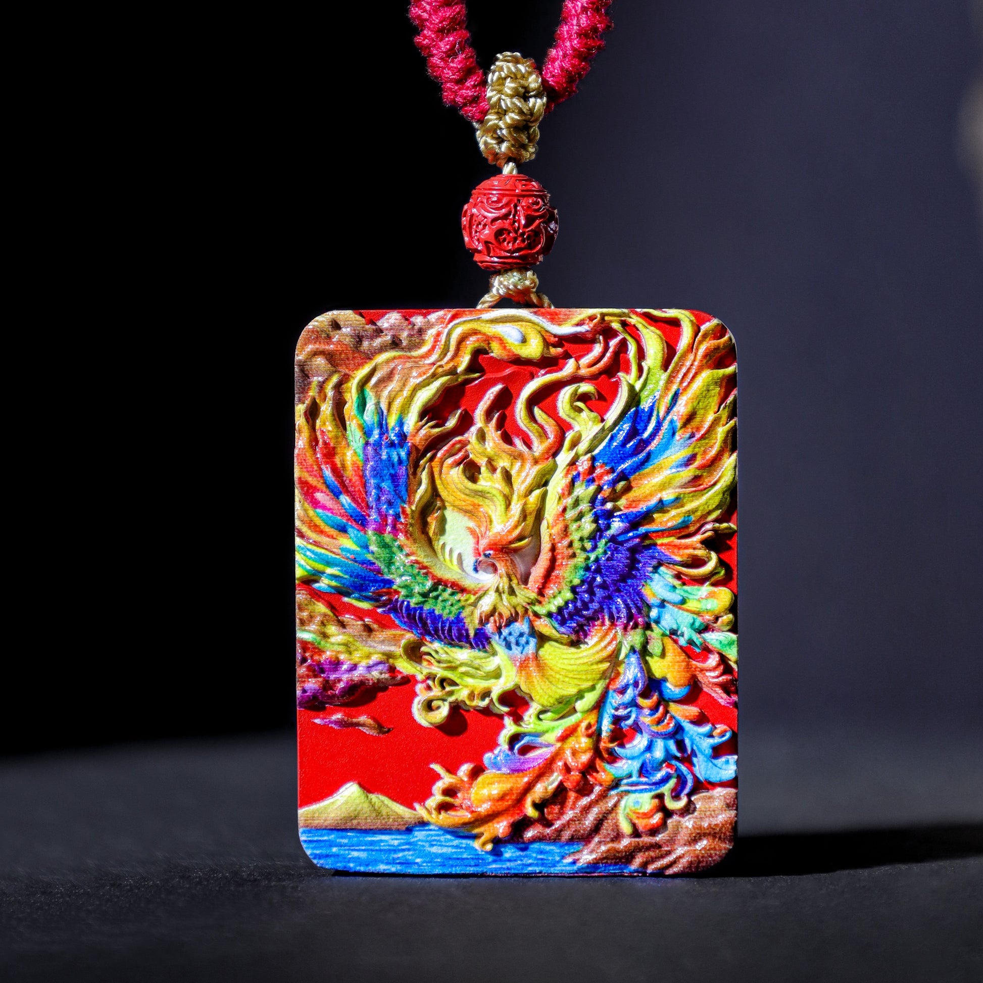 Colorful Cinnabar Fire Phoenix Thangka Pendant with intricate design and red cord for spiritual protection and good luck.