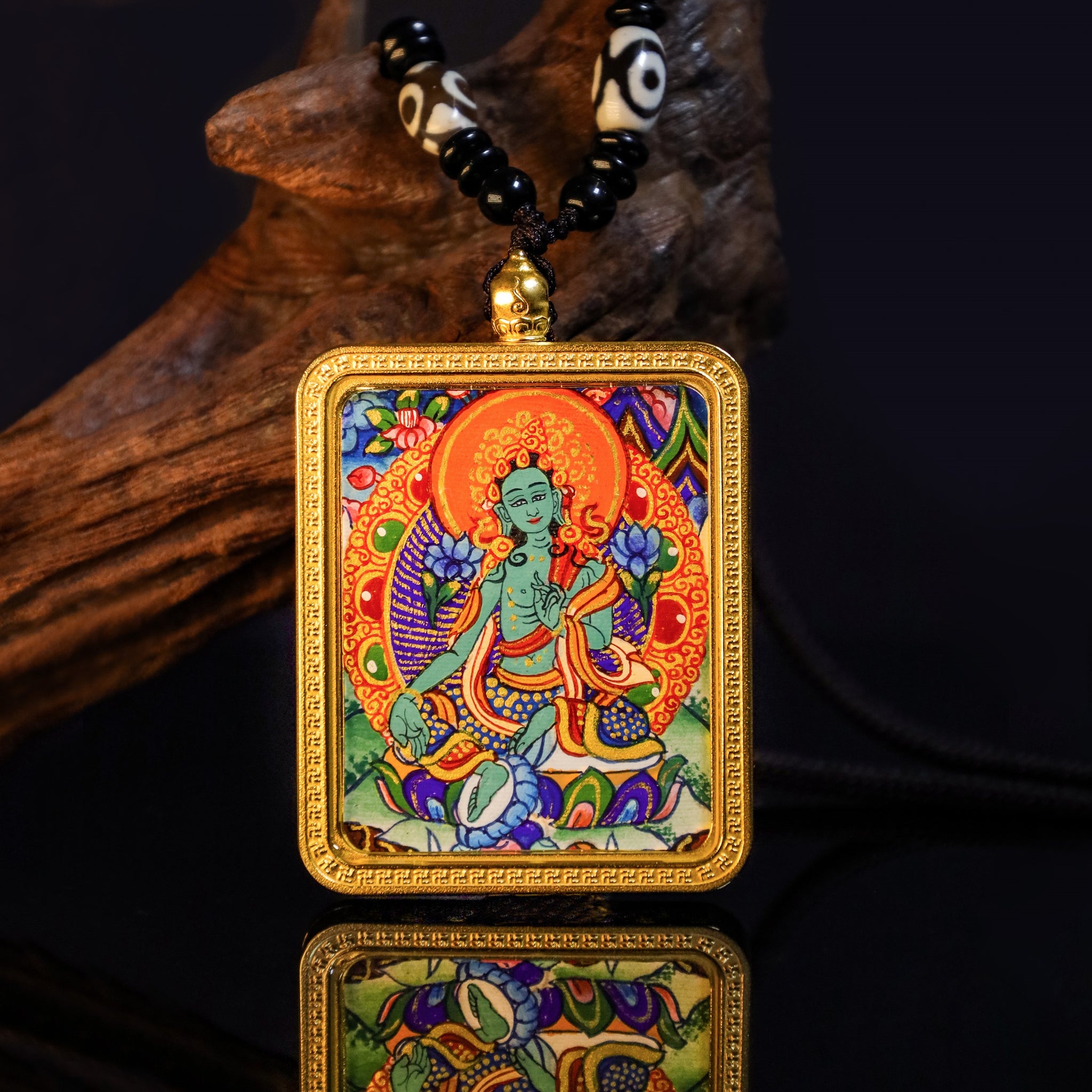 Hand-painted 24K Gold Green Tara Thangka Pendant with vibrant colors and intricate details, suspended on a decorative necklace.