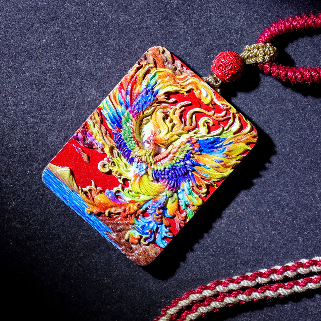 Colorful Cinnabar Fire Phoenix Thangka Pendant with intricate design and red cord for spiritual protection and good luck.